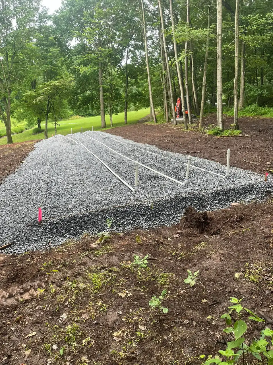 Gravel bed with pipe laterals laid out in a wooded clearing