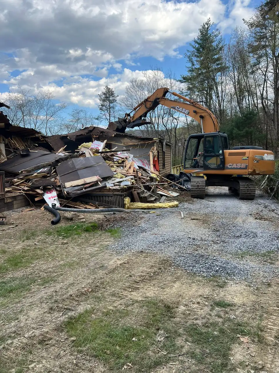 Excavator removing debris from demolished building